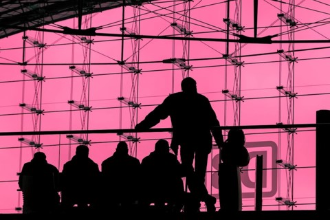 Silhouettes of travellers waiting for trains in the main station building