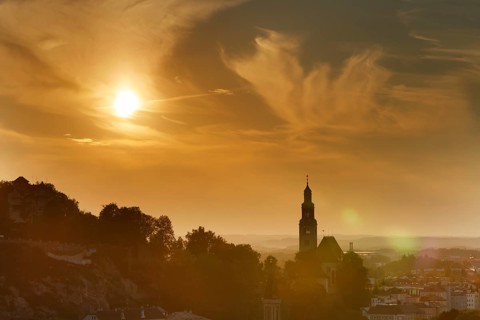 Moenchsberg mountain and Augustinerkirche church in Muelln in the evening light