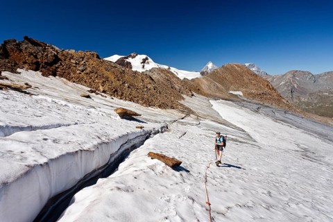 Hiker climbing to the peak of Cima Venezia mountain
