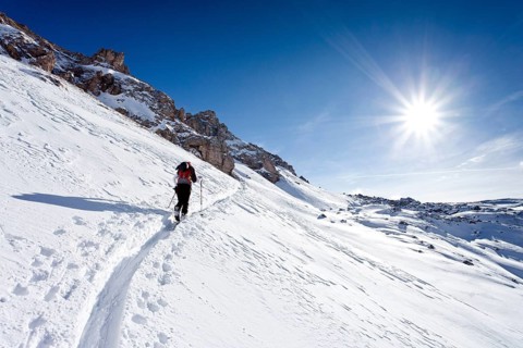Cross-country skier ascending Zendleser Kofel Mountain in Villnoesstal valley