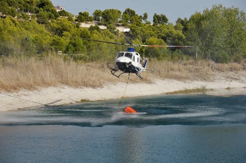 Fire helicopter getting water from a small artificial lake near Altea La Vella
