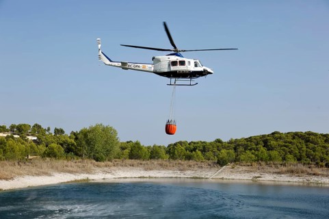 Fire helicopter getting water from a small artificial lake near Altea La Vella