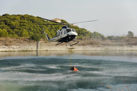 Fire helicopter getting water from a small artificial lake near Altea La Vella