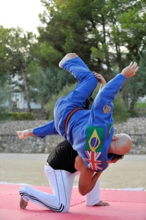 A martial arts instructor is demonstrating a shoulder throw with a student