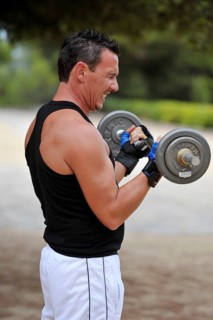 Man lifting weights while exercising in a park