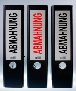 Three ring binders labelled 'ABMAHNUNG'