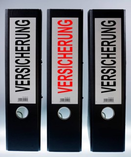 Three ring binders labelled 'VERSICHERUNG'