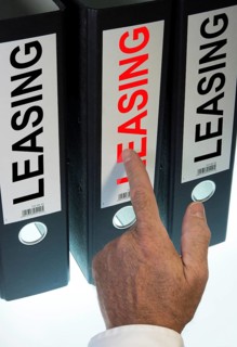 Hand pointing to a ring binder labelled "LEASING"
