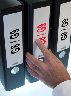 Hand reaching for a file folder labeled 'G8 - G9'