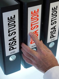 Hand reaching for a file folder labeled 'PISA-Studie'