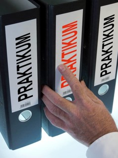 Hand reaching for a file folder labeled 'Praktikum'