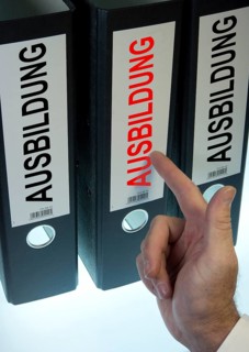 Hand pointing to a file folder labeled 'Ausbildung'