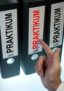 Hand pointing to a file folder labeled 'Praktikum'
