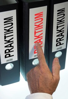 Hand pointing to a file folder labeled "Praktikum"
