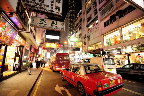 A red taxi on a street in the Tsim Sha Tsui district in the evening