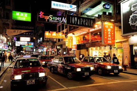 Red taxis on a street in Tsim Sha Tsui at night
