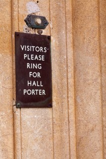 Visitors please ring for hall porter' sign by door bell button