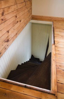 Trap door for wooden staircase leading to the downstairs floor of an old Canadiana cottage style residential home