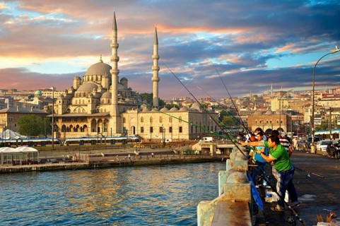 Fisherman on the Galata bridge fishing in the Golden Horn next to The Yeni Camii