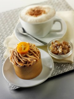 A modern Japanese cake with a pattered chocolate case and piped chestnut puree with cumquat sauce