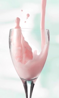 Fresh flavoured milk being poured into a glass