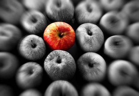 Single red apple amongst other apples