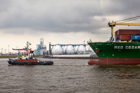 Tug boat towing a container ship on the Elbe