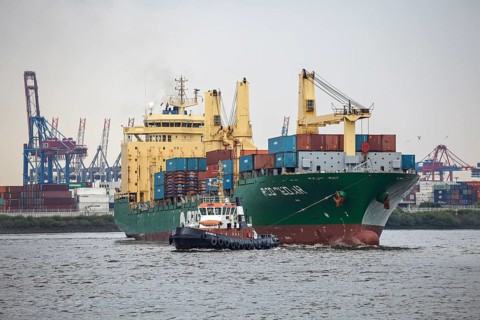 Tug boat towing a container ship on the Elbe
