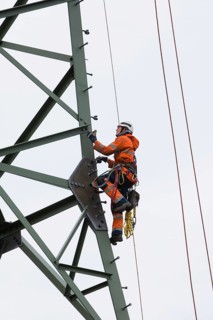 Lineman working with a wire rope hoist on a 380-kV long-distance line owned by the 50Hertz transmission system operator