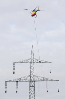 Lineman working with a wire rope hoist on a 380-kV long-distance line owned by the 50Hertz transmission system operator