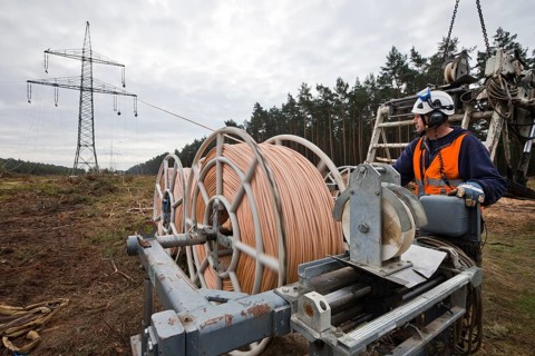 Lineman working with a wire rope hoist on a 380-kV long-distance line owned by the 50Hertz transmission system operator