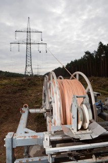 Lineman working with a wire rope hoist on a 380-kV long-distance line owned by the 50Hertz transmission system operator