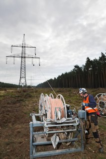 Lineman working with a wire rope hoist on a 380-kV long-distance line owned by the 50Hertz transmission system operator