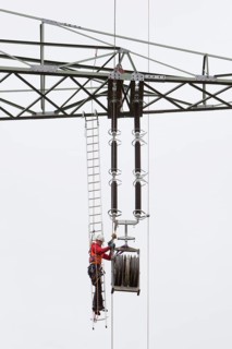 Lineman working with a wire rope hoist on a 380-kV long-distance line owned by the 50Hertz transmission system operator