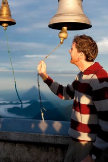 Man ringing a bell at a Buddhist temple