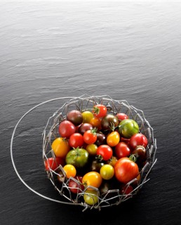 Various wild tomatoes in a wire basket