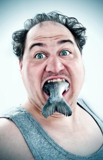 Chubby man with a fish in his mouth
