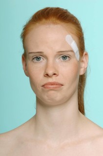Young red-haired woman with a plaster