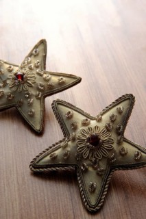 Golden textile stars on a wooden surface