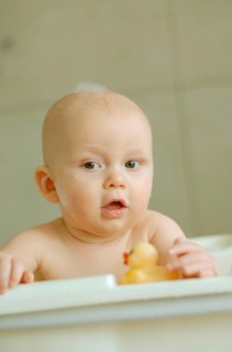 Baby in a bath with foam on his head