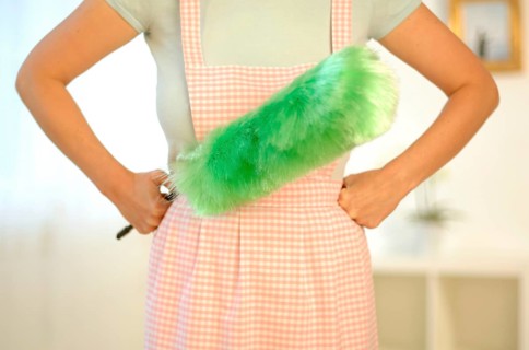 Housewife wearing an apron and holding a feather duster