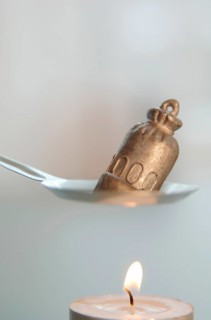 Tin or lead being molten before it is dropped into cold water from which the future is read on New Year's Eve