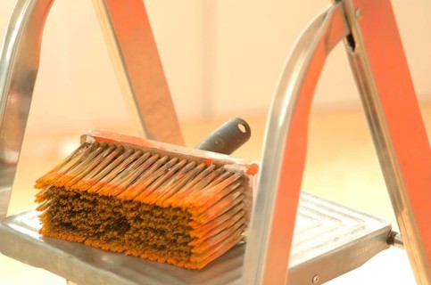 Large used paint brush lying on a ladder