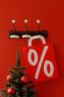 Shopping bag with per cent sign hanging on nostalgic coat hooks