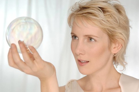 Blonde woman holding a glass sphere