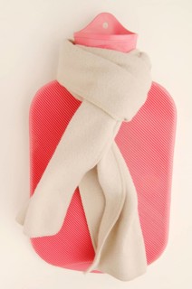Pink hot water bottle with a winter scarf