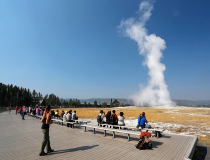Tourists watching the eruption of the Old Faithful geyser