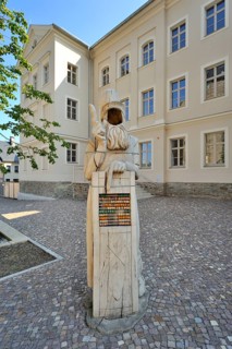 Wooden sculpture of Adam Ries in front of the Adam Ries educational centre