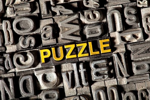 Old lead letters forming the word 'PUZZLE'
