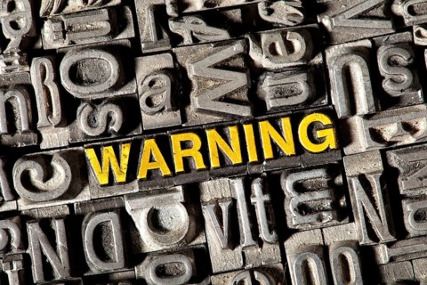 Old lead letters forming the word Warning